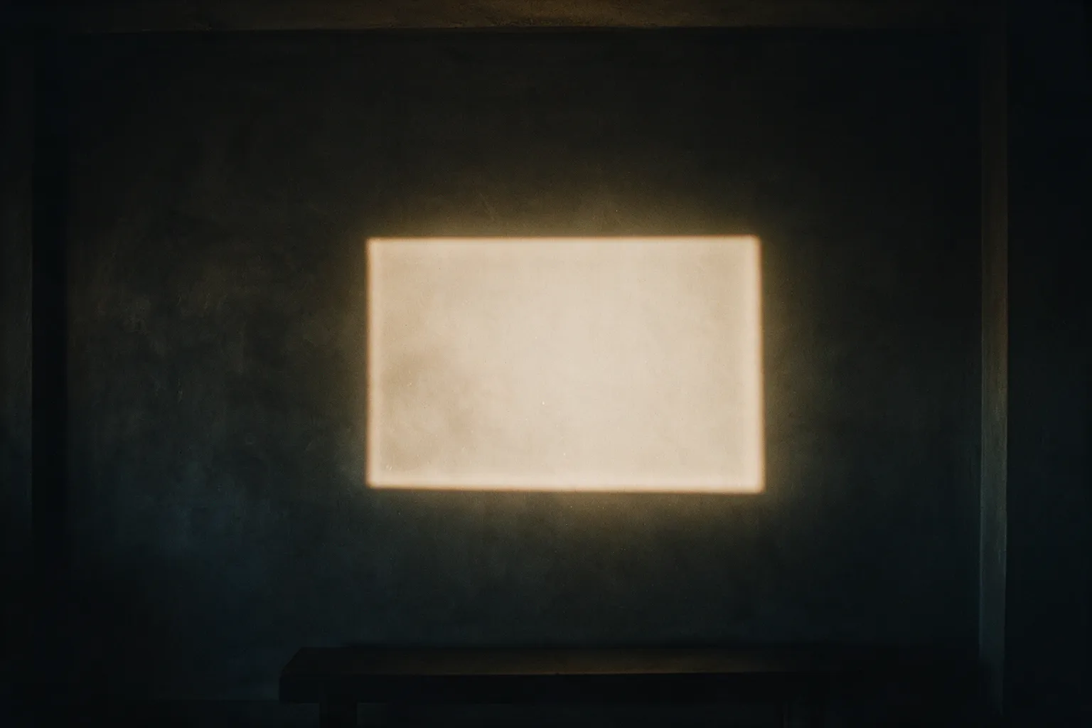 Illustrative dark room at night with a projector lighting an empty rectangle on a bare wall